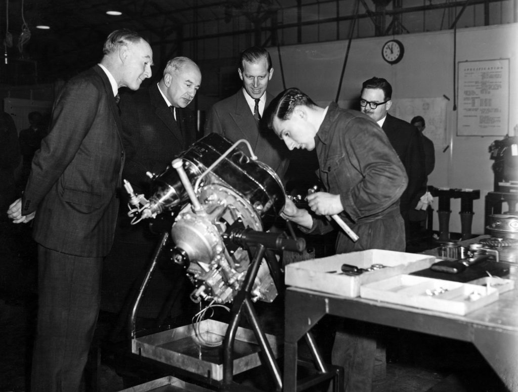 Prince Philip, The Duke of Edinburgh, visiting the Rover company in Solihull, West Midlands. The Duke admires a gas turbine unit, Mr Roy Bent, who is working on the unit, had to answer many questions. With the Duke are Mr M C Wilks and Mr G Searle. February 1958.