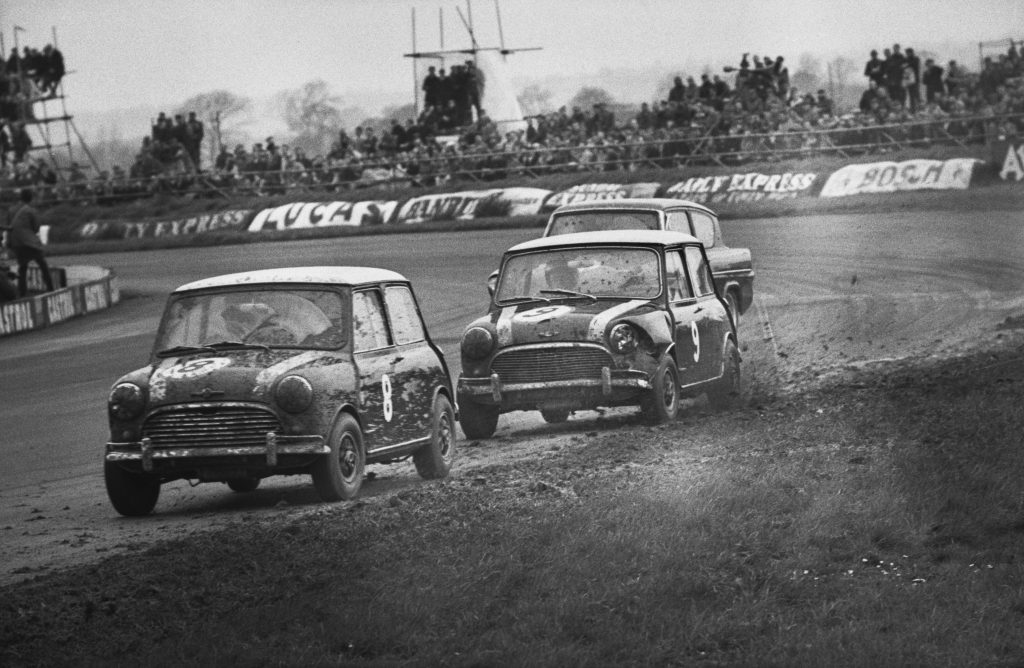 Racing driver Paddy Hopkirk driving an Austin Mini Cooper S (number 8) and John Fitzpatrick driving a Morris Mini Cooper S (number 9) during the International Production Touring Car Race in the 16th International Trophy Meeting at Silverstone, UK, 2nd May 1964. 