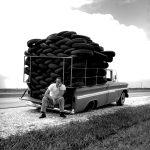 A tire truck gets a flat tire circa 1960