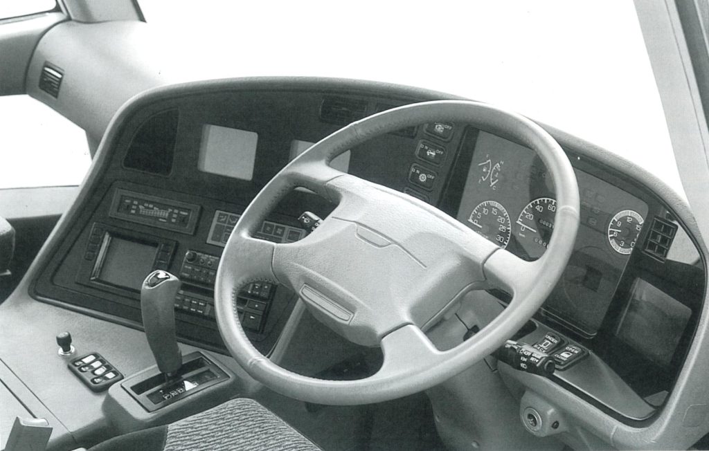 A fairly conventional cockpit, save for the slew of screens serving as side-view mirrors, navigation aids, etc. Early 3000GT/ Dodge Stealth owners may recognize the airbag-equipped steering wheel